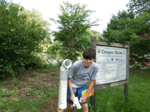 Jake Peacock, student at Haddonfiled Memorial High School, at the Cooper River collecton bin